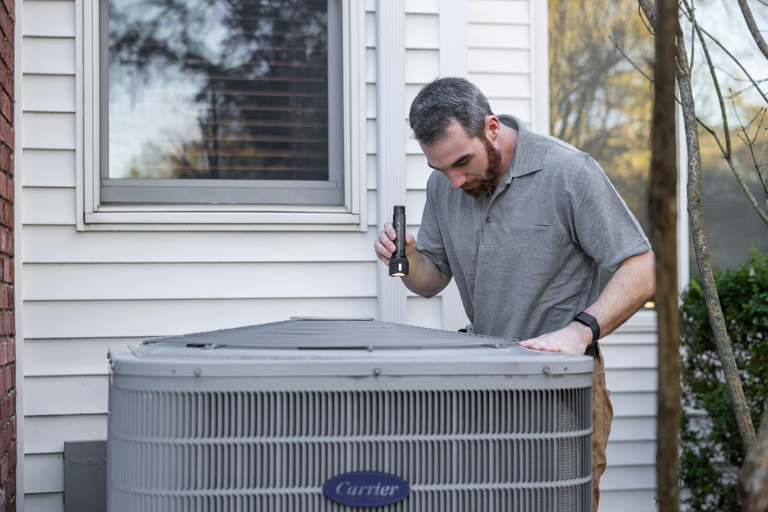 Technician performing fall HVAC maintenance