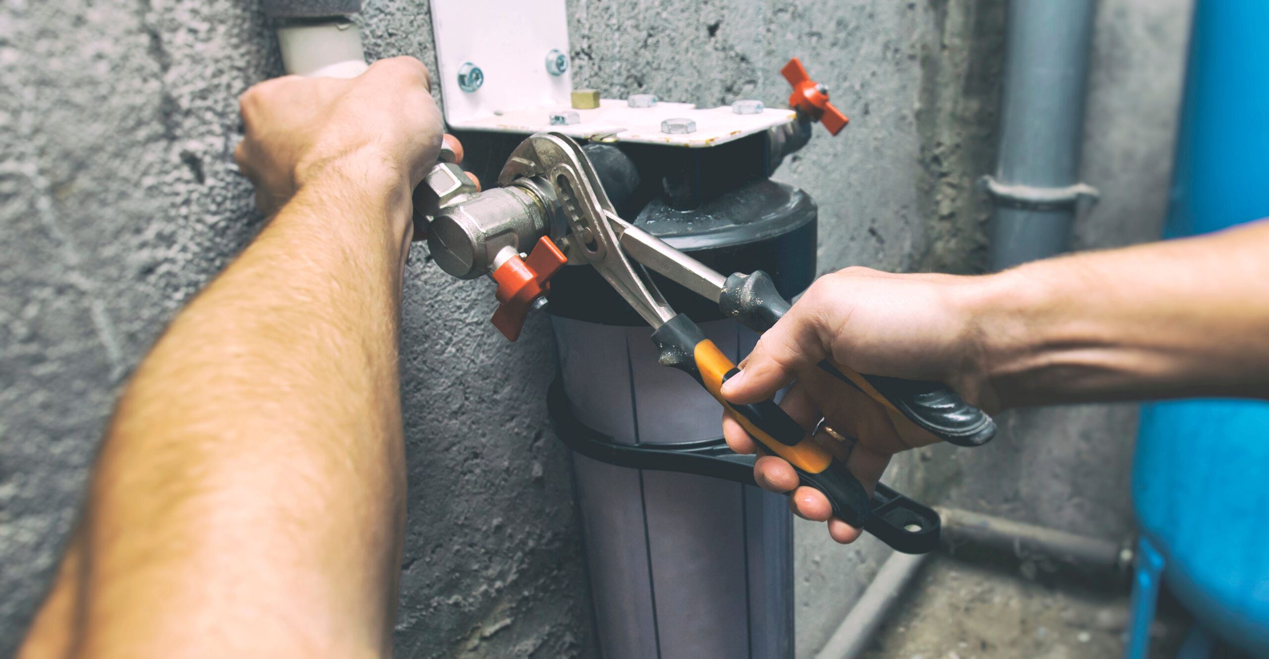 The plumber is repairing the water filter in the basement